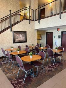 a group of tables and chairs in a room at GrandStay Hotel & Suites Becker in Becker
