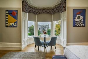 a living room with a table and chairs and a window at 8QR Rooms in Aberdeen