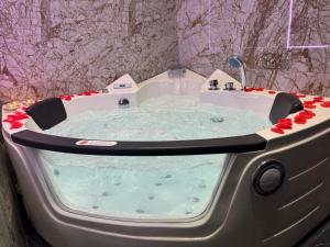 a jacuzzi tub in a bathroom with red roses at Gold House Roma in Rome +18 photos