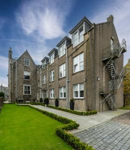 an apartment building with a green lawn in front at 8QR Rooms in Aberdeen