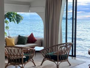 a living room with a couch and chairs and the ocean at Villa seafront Baan Chom-Ley Boutique villa in Hinkong