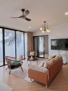 a living room with a couch and chairs and windows at Villa seafront Baan Chom-Ley Boutique villa in Hinkong