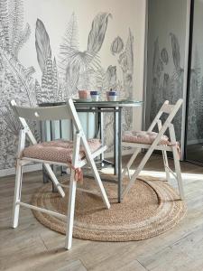 una mesa de cristal con 2 sillas y una mesa con plantas en La Mariennée, en La Rochelle