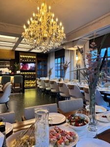 a dining room with tables and chairs and a chandelier at Villa Domenico Korce Old Bazaar in Korçë
