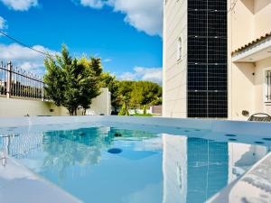 a swimming pool in front of a building at Airfenos - Athens Riviera in Anavyssos