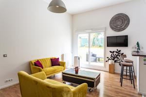 Sala de estar con 2 sillas amarillas y mesa en Loft calme et accueillant Metro Hoche Paris, en Le Pré-Saint-Gervais