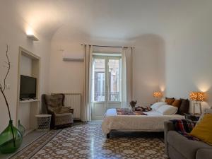 Un dormitorio con una cama, un sofá y un televisor. en B&B del Parlamento, en Palermo
