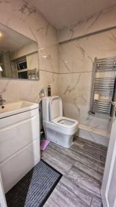 a bathroom with a white toilet and a sink at Lizola Homes Rooms in Dagenham