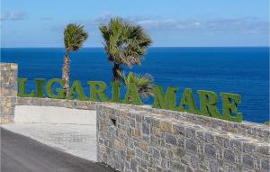 a sign on a wall with palm trees and the ocean at Beautiful Home In Heraklio Crete in Lygaria +13 photos