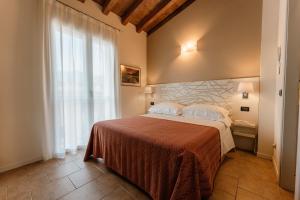 a bedroom with a bed and a large window at Hotel Eden Salò in Salò