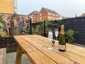 a bottle of champagne and two glasses on a wooden table at Egerton House Penrith in Penrith