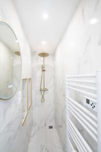 a bathroom with a mirror and white marble walls at Beau Studio Rénové - Lille JB Lebas in Lille