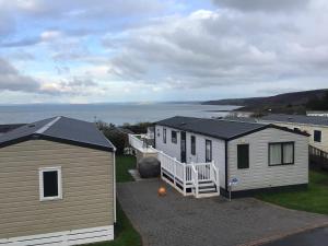 a couple of tiny houses sitting on top of a yard at Newquay Haven caravan 42x14 with Ocean Views in New Quay