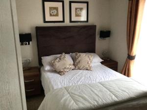 a bedroom with a bed with pillows on it at Newquay Haven caravan 42x14 with Ocean Views in New Quay