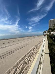 a sandy beach with a white fence and palm trees at Miami Hollywood Great 2 Bedroom with Garden View 001-22bmar in Hollywood