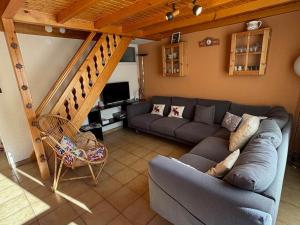 ein Wohnzimmer mit einer Couch und einer Treppe in der Unterkunft Spacieux appartement 2 chambres avec balcon ensoleillé - FR-1-692-82 in La Chapelle-dʼAbondance