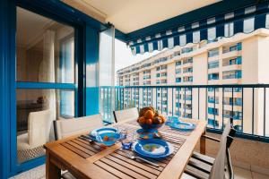 a table with a bowl of fruit on a balcony at RESORT BEACH VALENCIA in Valencia