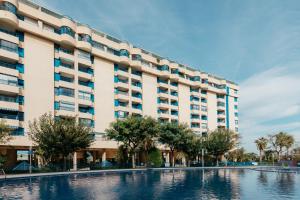 a large building with a pool in front of it at RESORT BEACH VALENCIA in Valencia