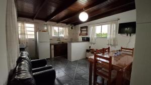 a kitchen and a living room with a table and a refrigerator at Hermoso apartamento en el centro de Atlántida in Atlántida