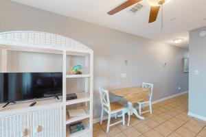 a living room with a table and a tv and a dining room at Nautical Watch A2 in Panama City Beach
