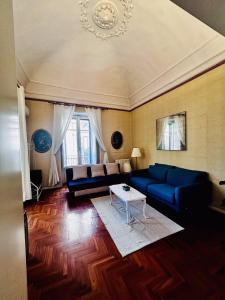 a living room with a blue couch and a table at Gli appartamenti di Agata in Catania