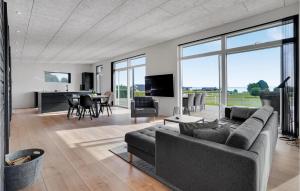 a living room with a couch and a dining room at 3 Bedroom Lovely Home In Sjølund in Sjølund