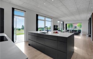 a kitchen with a black and white counter and a living room at 3 Bedroom Lovely Home In Sjølund in Sjølund