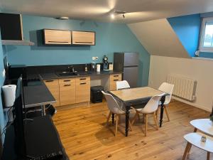 eine Küche mit Tisch und Stühlen in einem Zimmer in der Unterkunft Le studio 99 in Neuville-Saint-Rémy