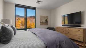a bedroom with a large bed and a television at Lux Mountainside 2 Bed Mountainside Condo By Stowe Mountain Rentals in Stowe