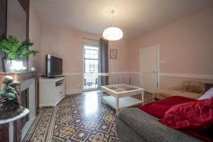 a living room with a couch and a tv at Casa Soma in Saint-Marcel