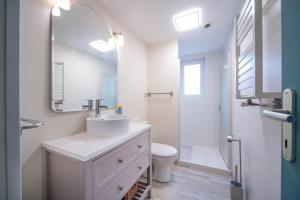 a white bathroom with a sink and a mirror at Casa Soma in Saint-Marcel +17 photos
