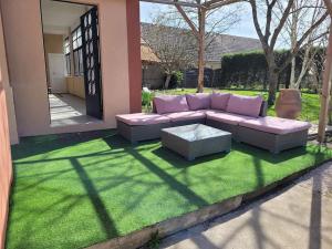 a couch sitting on a patch of grass in a yard at Casa Soma in Saint-Marcel