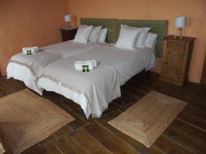 two beds in a hotel room with towels on them at Casa de las Eras in Valdesimonte