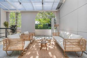 a living room with wicker chairs and a couch at NOWA Provenza 3-Story Villa with Pool & Rooftop in Medellín