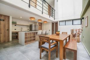 a kitchen and dining room with a wooden table and chairs at NOWA Provenza 3-Story Villa with Pool & Rooftop in Medellín