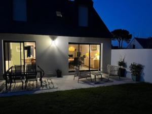 a patio with two benches and a table in front of a house at Maison moderne et chaleureuse, emplacement idéal in Arzon