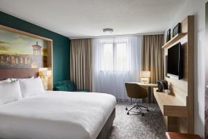 エディンバラにあるLeonardo Hotel Edinburgh Haymarketのベッドと机があるホテルの部屋