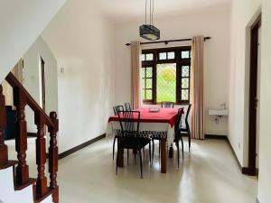 a dining room with a red table and chairs at Blue Ridge Homestay in Kandy