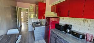 a kitchen with red cabinets and a red refrigerator at Apartament Tkaczy in Kowary