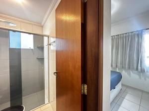 a bathroom with a shower and a glass door at Apartamento pé na areia in Ubatuba