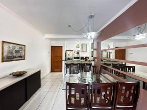 a large kitchen with a glass table and chairs at Apartamento pé na areia in Ubatuba