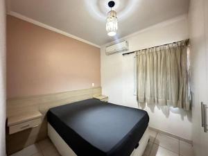 a bedroom with a black bed in a room at Apartamento pé na areia in Ubatuba +30 photos
