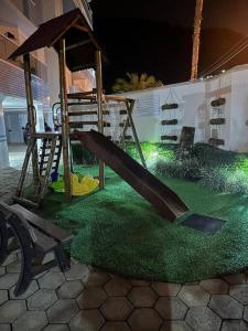 a park with a playground with a slide and grass at Apartamento pé na areia in Ubatuba