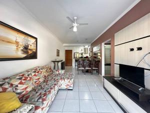 a living room with a couch and a tv at Apartamento pé na areia in Ubatuba