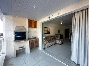 a room with a kitchen and a living room with a couch at Apartamento pé na areia in Ubatuba