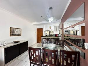 a kitchen with a glass table and chairs at Apartamento pé na areia in Ubatuba