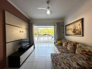 a living room with a couch and a television at Apartamento pé na areia in Ubatuba