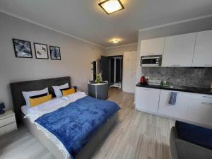 a bedroom with a large bed and a kitchen at Villa6 in Pobierowo