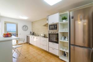 a kitchen with white cabinets and a stainless steel refrigerator at Villa Humaik by Villa Plus in Antigua