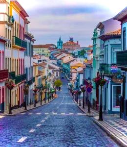 Blick auf eine Stadtstraße mit bunten Gebäuden in der Unterkunft Time to Travel to Terceira in Pesqueiro
